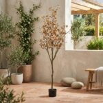 עץ מלאכותי עם עלים בצבעי סתיו בעציץ שחור